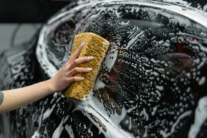 imagen de una mano lavando un coche para prevenir problemas de corrosión en Hyundai Tucson